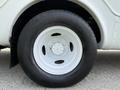 A white wheel and tire of a 2010 Ford Econoline showing the rim design and tire tread