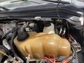 The image shows the engine compartment of a 2010 Ford F-550 with a focus on the large coolant reservoir and various engine components and wiring visible