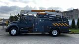 A blue 2009 International 4300 utility truck with a mounted aerial lift and various tool compartments on the side