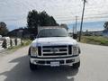 A white 2010 Ford F-550 with a silver grille and amber clearance lights parked on a roadway