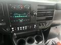 Interior dashboard of a 2017 Chevrolet Express featuring a central control panel with climate controls audio system and various buttons and knobs