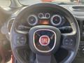 The steering wheel of a 2015 Fiat 500L featuring the Fiat logo and various control buttons on the wheel and dashboard displays