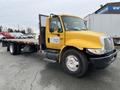 A yellow 2007 International 4300 flatbed truck with a black chassis and a sign on the door for Intercity Cartage