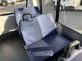 Two blue fabric seats with black armrests inside a vehicle