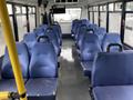 Interior of a 2017 Chevrolet Express with blue upholstered seats arranged in rows and a yellow handrail along one side