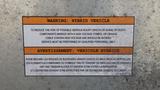 A 2011 Ford Econoline with a warning label about hybrid vehicle risks and maintenance requirements