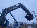 A 2014 John Deere 350G excavator with a large digging bucket attached to its arm