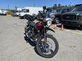 A 2022 Royal Enfield Himalayan motorcycle with a black and red color scheme, featuring a high-mounted front fender, a round headlight, and an upright riding position