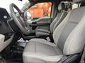 A 2017 Ford F-150 interior featuring two gray cloth seats with armrests and a central console