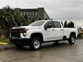 A white 2021 Chevrolet Silverado 3500HD with a black grille and chrome accents parked with a spacious bed and a large cab