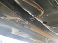 A close-up view of the undercarriage of a 1966 Ford Mustang showing the exhaust system and suspension components