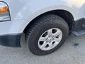 Close-up of the front wheel and tire of a 2013 Ford Expedition showing a silver alloy rim and tread pattern on the tire