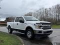 White 2018 Ford F-150 pickup truck with a black grille and chrome accents parked at an angle