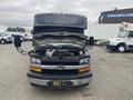 A 2018 Chevrolet Express van with its hood open displaying the engine compartment and front grille visible