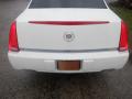 A white 2008 Cadillac Limousine with distinctive tail lights and a Cadillac emblem on the rear