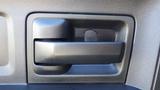 Close-up of a door handle from a 2014 RAM 3500 featuring a sleek black design with angular edges