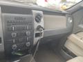 Interior view of a 2009 Ford F-150 with a dashboard featuring various buttons knobs and a center console