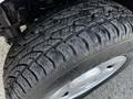 A close-up of a 2008 Ford F-150 XL tire showing the tread pattern with visible water droplets on the surface