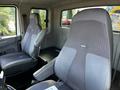 Two gray seats inside the cabin of a 2013 International DuraStar 4300 with a simple design and armrests