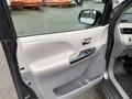 Interior view of a 2013 Toyota Sienna driver's side door with controls for windows and locks in light gray and black trim