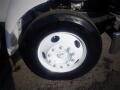 Close-up of a white tire and wheel from a 2007 Ford F-650 showcasing its five bolt holes and tread pattern