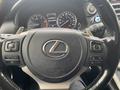 Steering wheel of a 2021 Lexus NX 300 featuring the Lexus logo with control buttons on the left and right sides