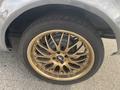 A close-up of a gold alloy wheel with a multi-spoke design and a black tire fitted to a 1966 Ford Mustang