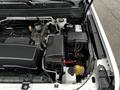 Under the hood of a 2019 Chevrolet Colorado showing the engine compartment with visible components like the battery coolant reservoir and various hoses and cables