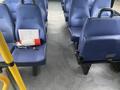 Interior view of a 2018 Chevrolet Express showing blue seating with a fire extinguisher and clipboard on the floor