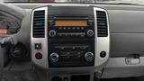 Dashboard of a 2016 Nissan Frontier featuring a central control panel with radio and climate controls