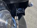 Close-up of a chrome footpeg and foot control on a 2004 Harley-Davidson Flhtcui motorcycle showcasing intricate design details and a polished surface