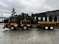 A 2015 International 3000 MT6 with a snowplow attachment and a tandem trailer designed for snow removal and maintenance