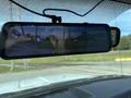 A rearview mirror showing a reflection of a 2010 Ford F-550 with visible dashboard indicators and a portion of the windshield