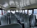 Interior of a 2016 International 4200 school bus with gray high-backed seats arranged in rows and a clear view of the aisle