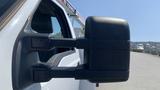 White 2011 Ford F-450 SD side mirror with a large black housing and integrated turn signal light