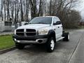 A white 2008 Dodge Ram 5500 pickup truck with a flatbed design and black front grille parked on a concrete surface