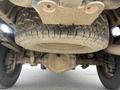 View of the underside of a 2010 Dodge Ram showing a large tire and the rear axle system