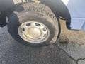 A close-up of a tire and wheel from a 2013 Ford F-150 showing a rugged tread pattern and a silver alloy rim