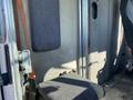 Interior of a 2006 Workhorse W42 displaying a gray upholstered seat next to a door and a wall with a circular window