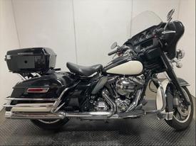 2016 Harley-Davidson Flhtp motorcycle featuring a black and white body chrome accents and a large windshield