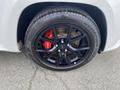 Close-up of a black alloy wheel with a red brake caliper on a 2018 Jeep Grand Cherokee tire