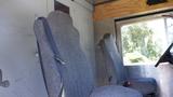 Two gray upholstered seats inside a vehicle with a simple interior design