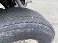 Close-up of a worn tire from a 2000 Ez-go Industrial 800 showing deep grooves and a slightly cracked sidewall