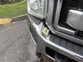 A close-up view of the front bumper of a 2013 Ford F-350 SD showing a connector piece attached to the chrome detailing