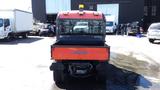 A 2013 Kubota RTV 1100 utility vehicle with an orange and black design featuring a rear bed and a safety light on top