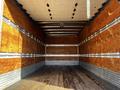 Interior of a 2020 Isuzu NPR box truck showing wooden walls and a wooden floor with metal strips along the lower edges