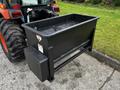 A black hydraulic loader bucket attached to a Kubota B2650 tractor designed for moving materials like dirt or gravel