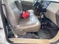 Interior view of a 2010 Ford F-550 featuring gray leather seats and a black floor mat with a small red bag on the seat