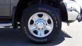 Close-up of a chrome wheel and tire from a 2014 RAM 3500 with the Bridgestone Dueler H/L tire model visible on the sidewall