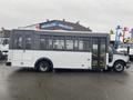 A white 2018 Chevrolet Express bus with large windows and a wheelchair access ramp on the side